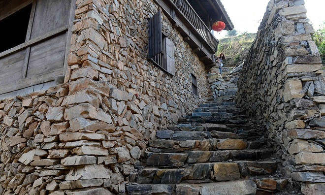 The village preserves many historical and cultural features, with yellow walls, black bricks, wooden houses, and stone staircases everywhere.